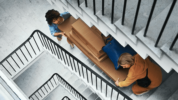 People carrying some boxes by the stairs