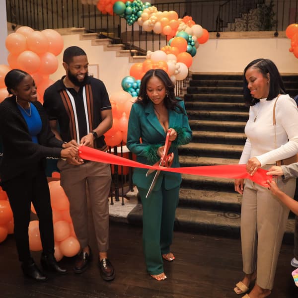 People cutting a ribbon with large scissors. 