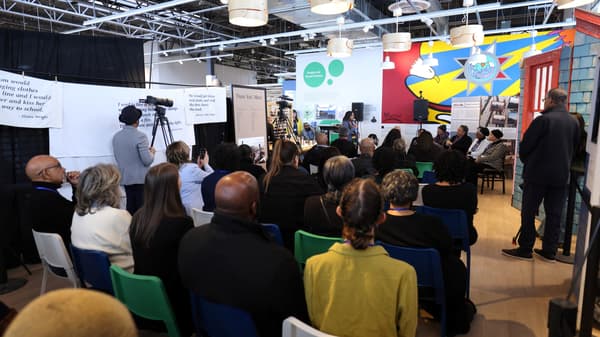 People seated in a room watching a presentation by the Africville Museum at IKEA Halifax
