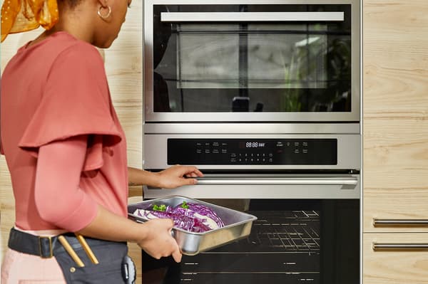 Persoa metendo unha bandexa nun forno de IKEA