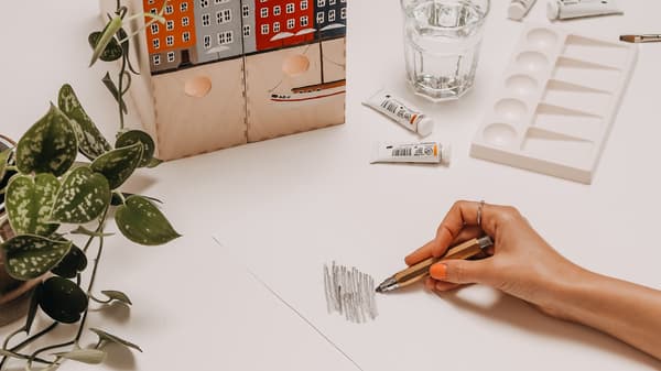 Person bemalt die Rückseite der Motiv-Vorlage mit Graphit.