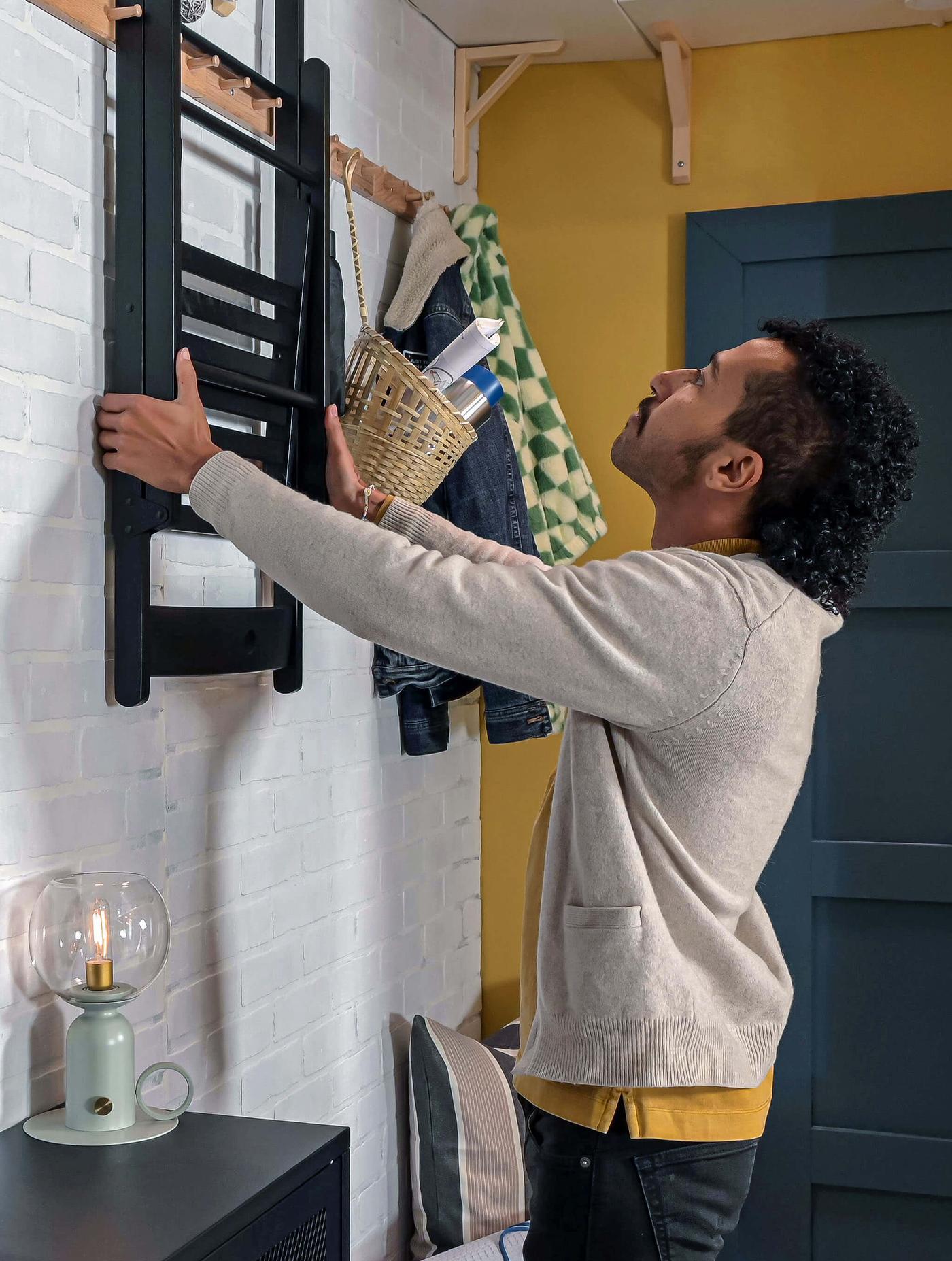 Person hanging chair on wall hook