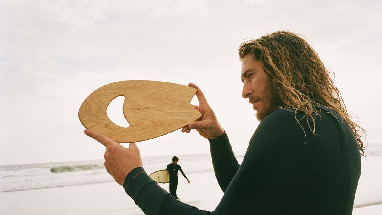 Person holding hand plane used for body surfing on beach
