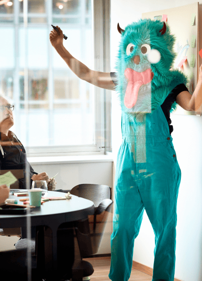 Person in an office in a blue monster costume
