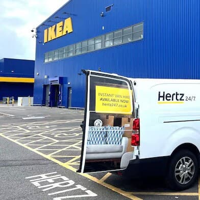 Person putting large parcel into van