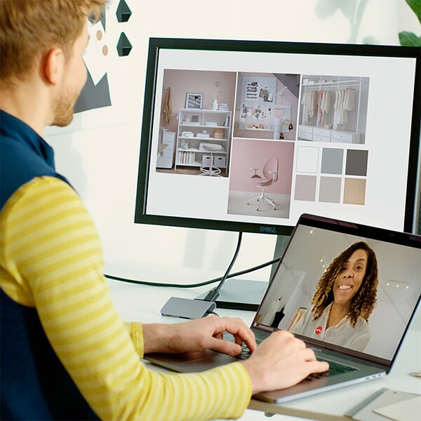 Person working on a laptop while viewing a home décor mood board on the monitor.