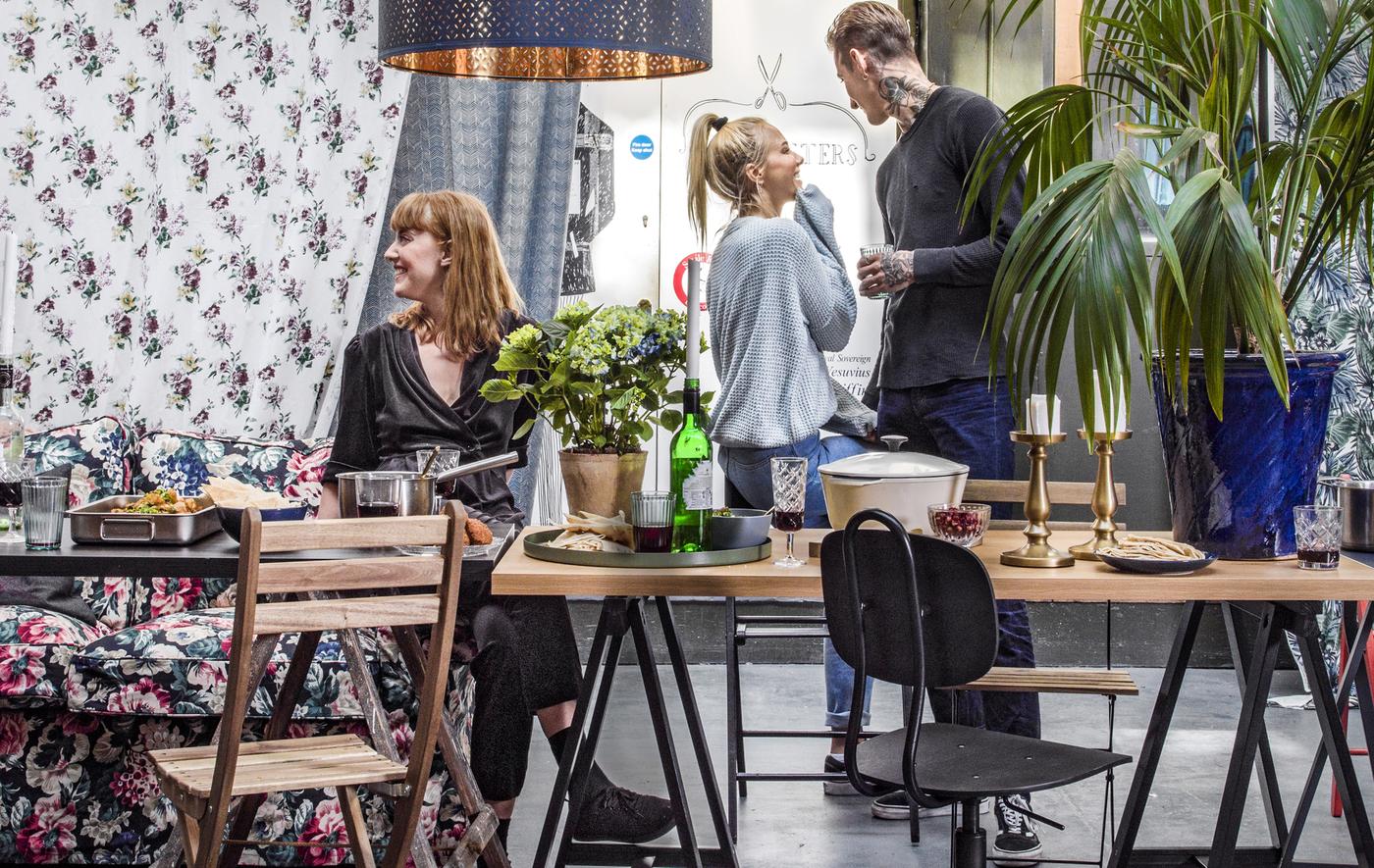 Persone che socializzano in una zona pranzo arredata con un mix di sedie e tavoli diversi - IKEA