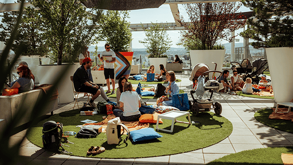 Personen picknicken auf grünen Rasenteppichen auf unserer Dachterrasse.