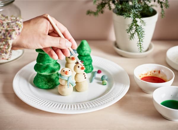 Personnages en massepain en train d'être peints avec des colorants alimentaires.