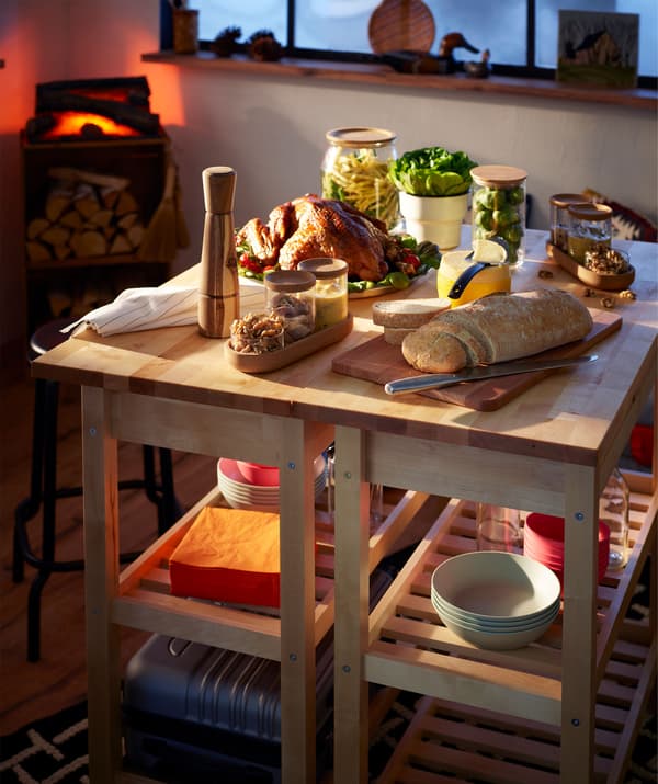 Petit buffet festif sur deux dessertes placées côte à côte; faux feu de bois à l’arrière-plan.