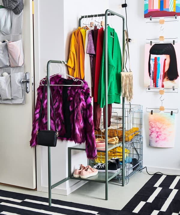 Petite armoire-penderie ouverte aménagée dans un coin de l’appartement. Elle comprend des portants en métal et des caissons en fil de métal.