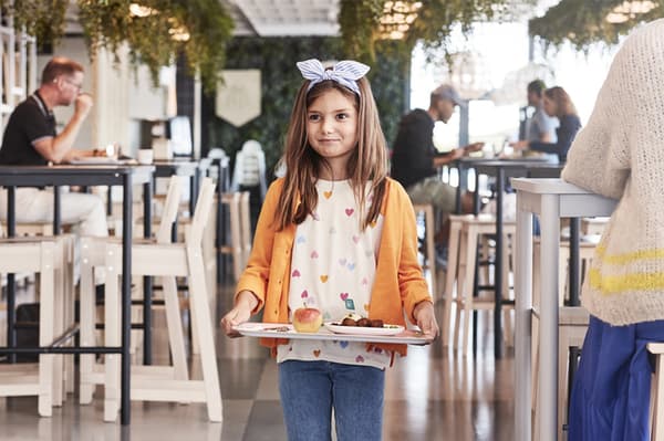 Petite fille qui profite du menu enfant IKEA.