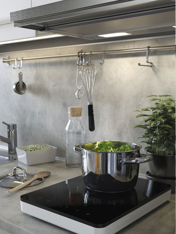Petite plaque de cuisson avec une casserole et des aliments qui cuisent.