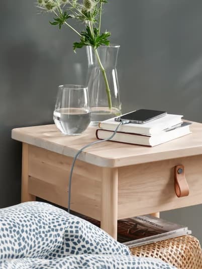 Phone cable on bedside table plugged into phone