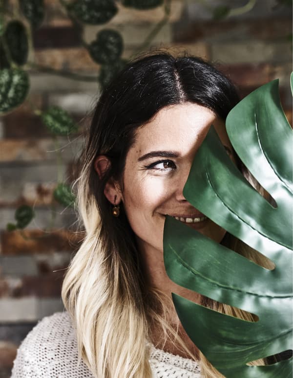 Photo de Miriam cachée derrière une feuille.