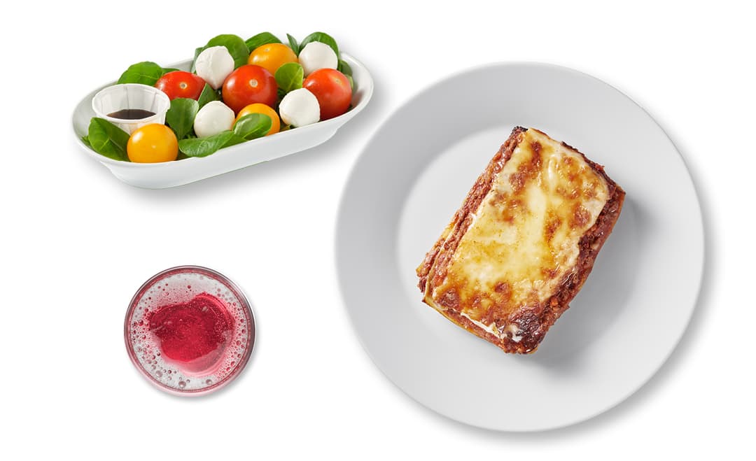 Photo du menu du mardi composé d'une salade tomate-mozzarella, d'une lasagne et d'une boisson.