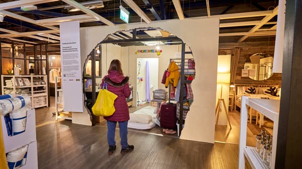 Picture of women with yellow IKEA bag in front of a Real Life Roomset in IKEA Warrington