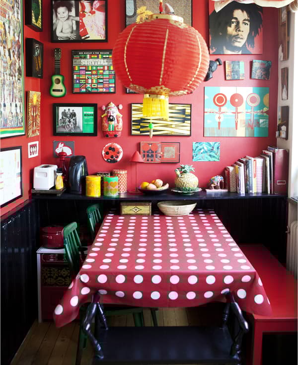 Pièce avec murs, nappe et sièges rouge et cadres au mur.
