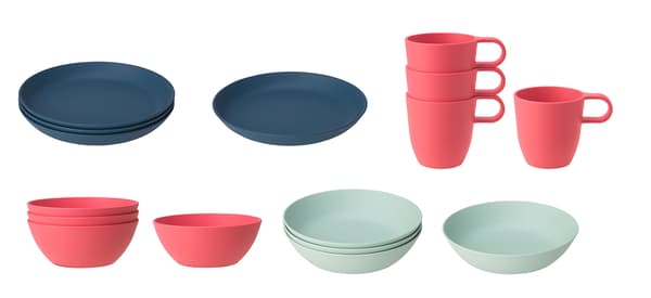 Pilas de platos azul oscuro, tazones y tazas rosas y tazones verde claro de la serie TALRIKA sobre un fondo blanco.