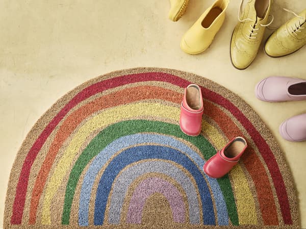 PILLEMARK rainbow rug surrounded with pairs of shoes