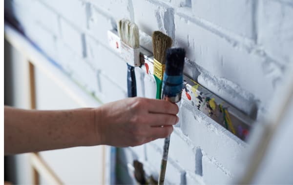 Pinceaux fixés sur un rail à couteaux magnétique fixé au mur.
