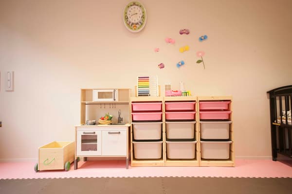 ピンクのボックスが印象的な収納棚と、おもちゃ部屋。