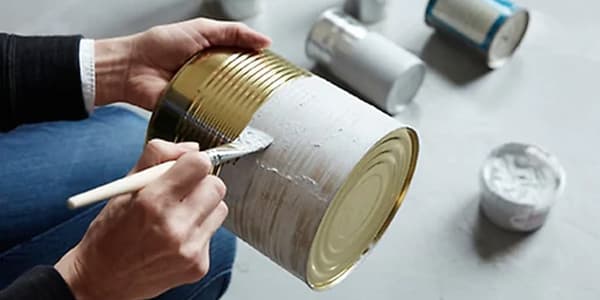 Pintando latas baleiras para facer recipientes de cociña.