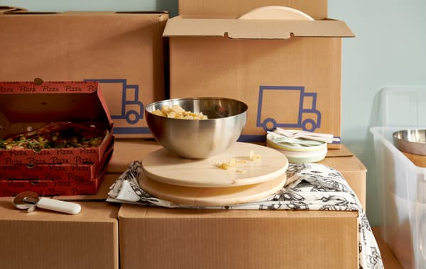 Pizza v krabicích a otočný tác s nerez mísou BLANDA BLANK, to vše postavené na krabicích JÄTTENE