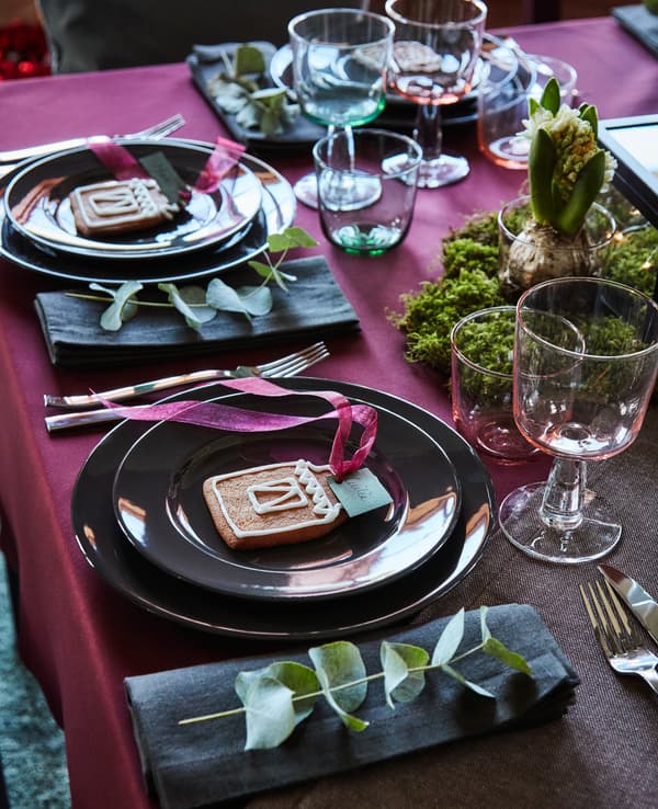 Place settings are decorated with gingerbread cookies and a sprig of eucalyptus.