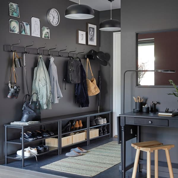 Place trois bancs/rangements chaussures noirs PINNIG et trois patères noires PINNIG contre un mur gris foncé pour créer plein de rangements dans un hall d’entrée étroit.