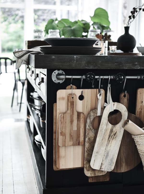 Planches à découper suspendues à une barre support dans la cuisine.