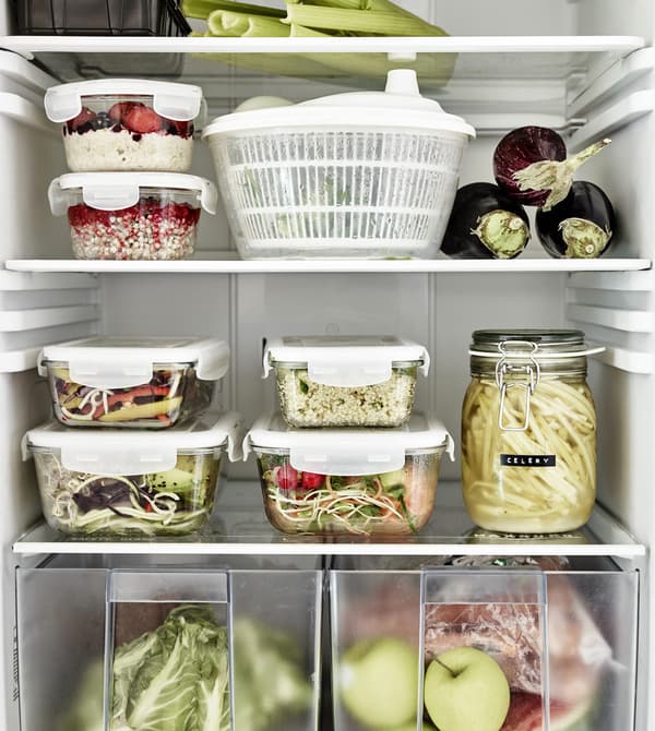 Plastic food containers stacked in a fridge.