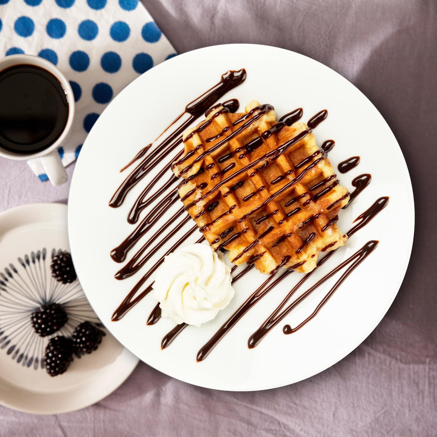 Plat amb un gofre, salsa de xocolata i una mica de nata