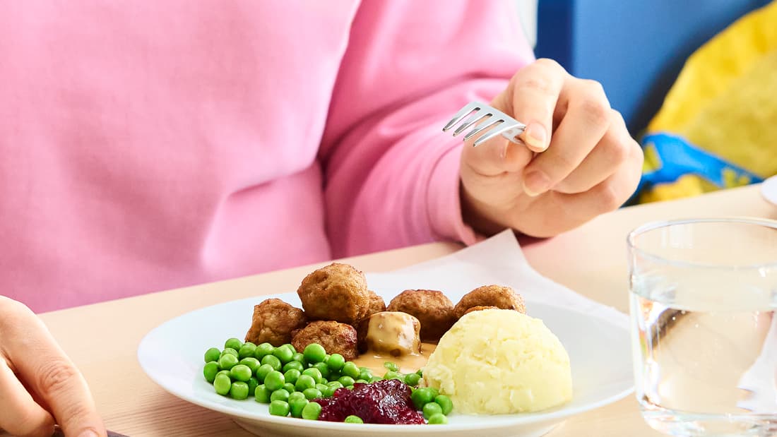 Plat de boulettes suédoises bien connues avec des petits pois, de la purée, de la sauce aux airelles et de la sauce pour boulettes.