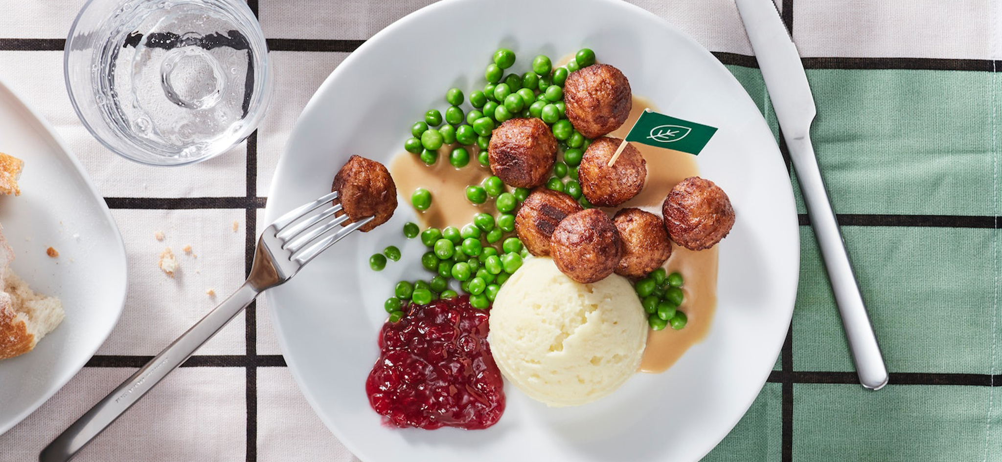 Plate of Swedish meatballs with mashed potatoes, peas, gravy and lingonberry jam at an IKEA Swedish Restaurant.