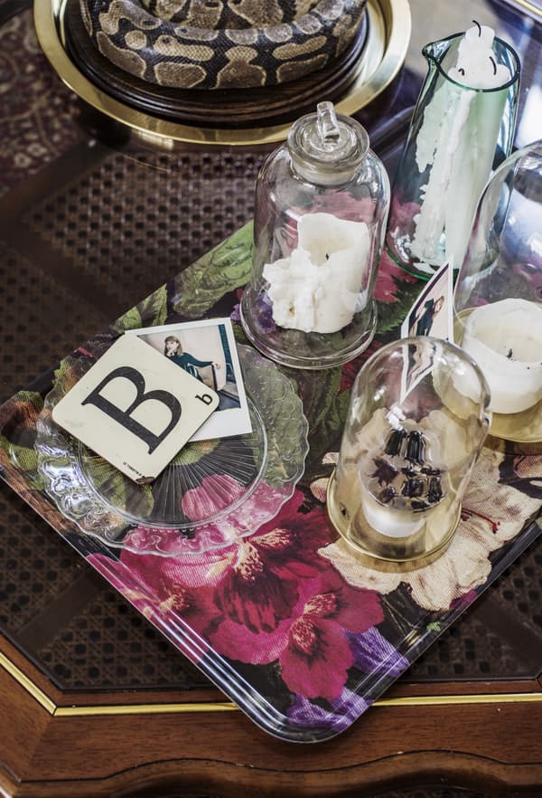 Plateau fleuri avec cloches en verre et bougies.