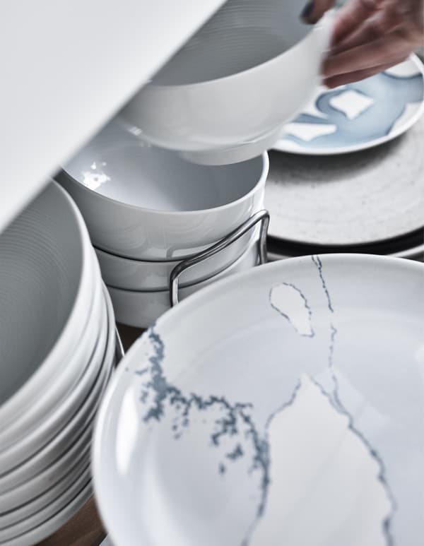 Plates and bowls stored in a deep drawer.