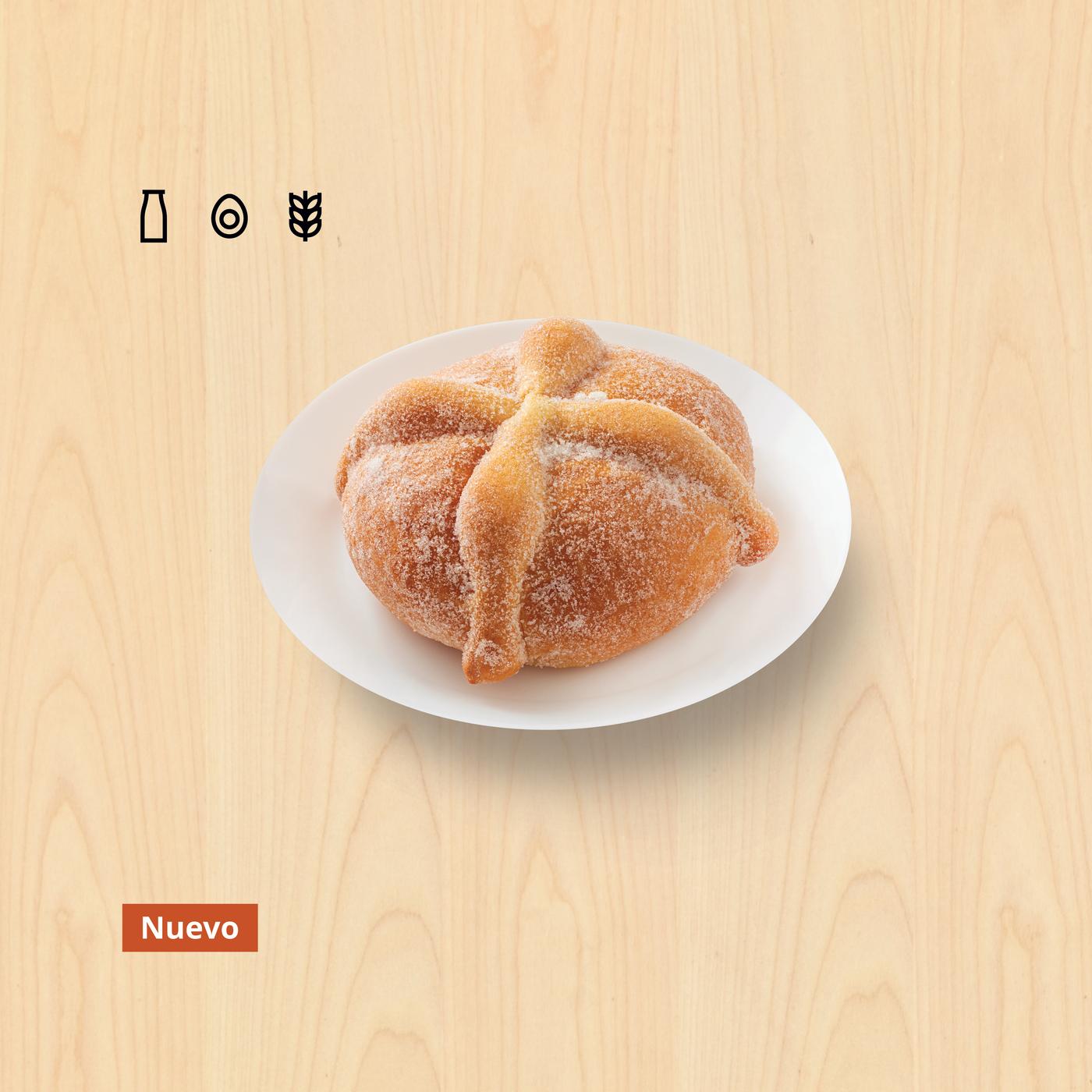 Plato con pan de muerto tradicional con un fondo de madera.