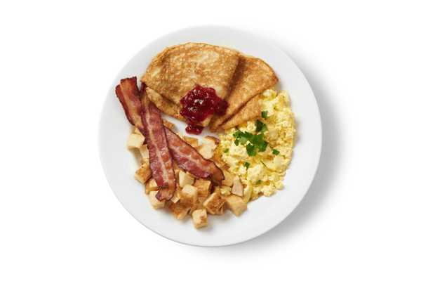 Plato de desayuno mediano, huevos, patatas y beicon, servido con tortitas suecas y mermelada de arándanos rojos