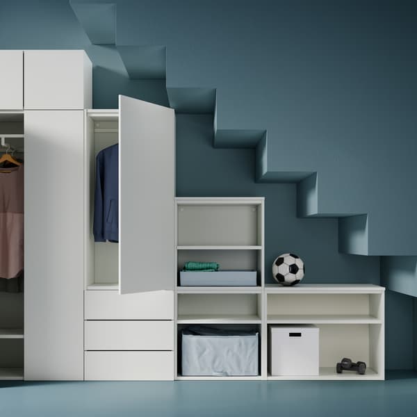 PLATSA gardróbkombináció különböző magasságú elemekkel, bennük ruhák, tárolódobozok, súlyzók és egy focilabda.