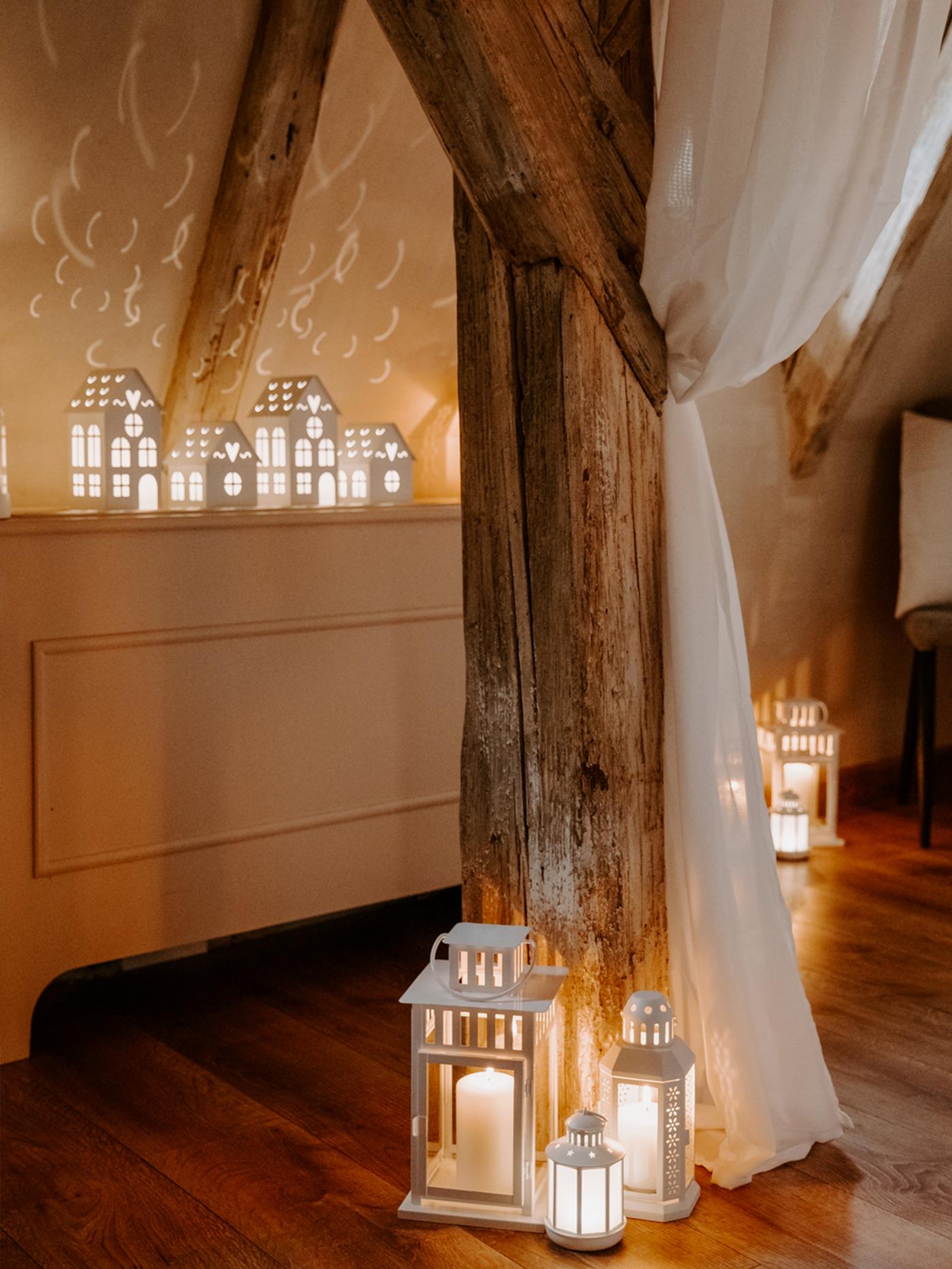 Plusieurs lanternes blanches décorent une pièce chaleureuse.