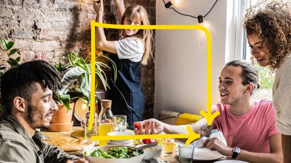 Plusieurs personnes sont assises autour d’une table et sourient