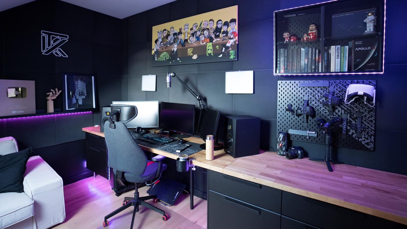 Pokój gamingowy z czarnymi ścianami i meblami z asortymentu gaminowego.