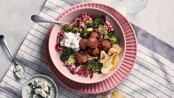 Polpette vegetali con insalata di quinoa in una ciotola rosa su un piatto rosa, sopra a uno strofinaccio a quadri bianco e grigio - IKEA
