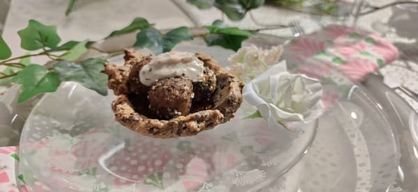 Polpette vegetali in crosta di sesamo e semi di chia in cestino di pane croccante poste su un piatto.