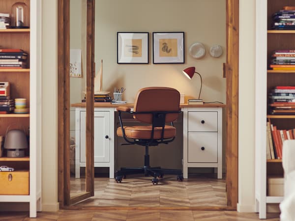 Portas da sala deixam antever um espaço de trabalho em casa tradicional com secretária HEMNES e cadeira giratória ALEFJÄLL.