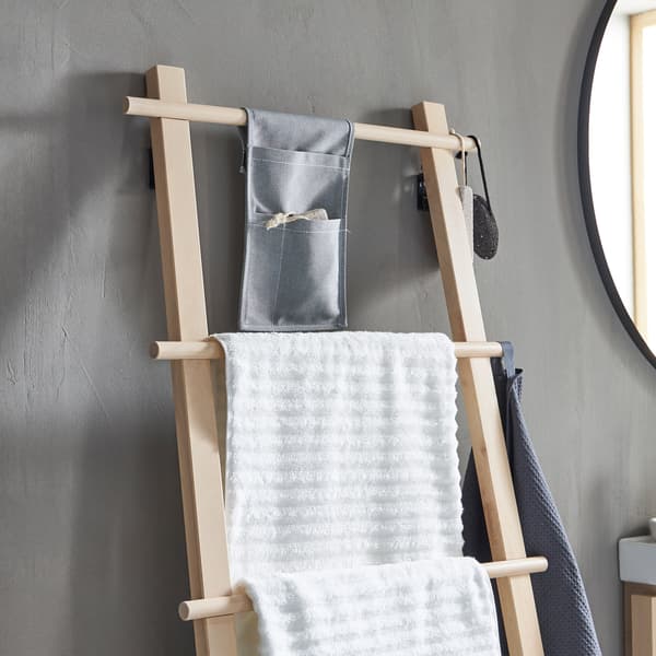 Portasciugamani VILTO in legno di betulla, a forma di scala, contro una parete grigia in un bagno minimalista.