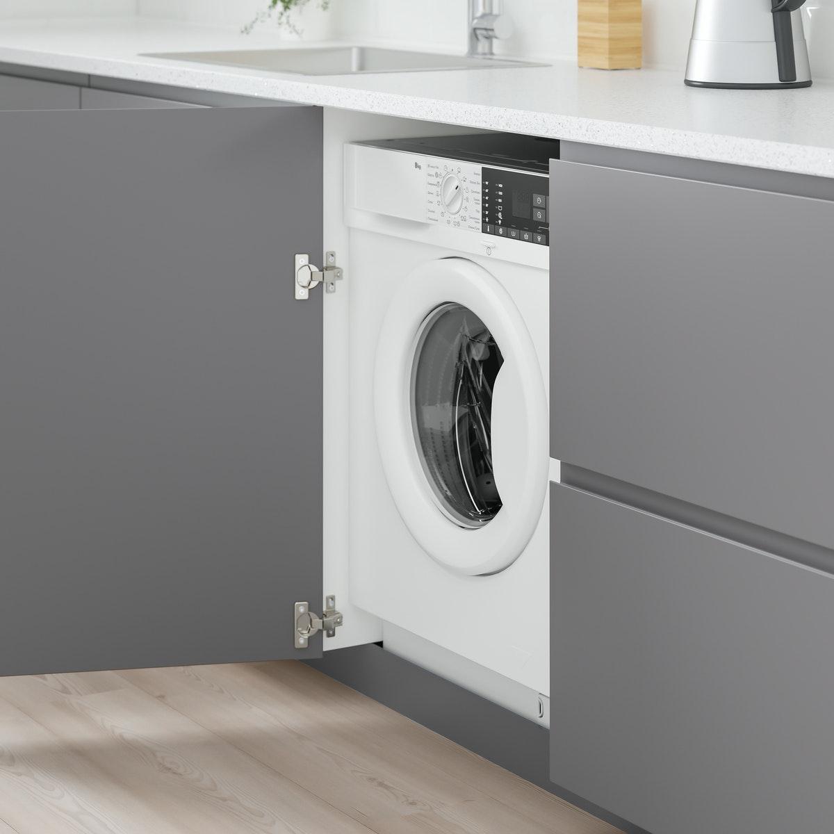 Porte de placard gris ouvert sur une machine à laver le linge