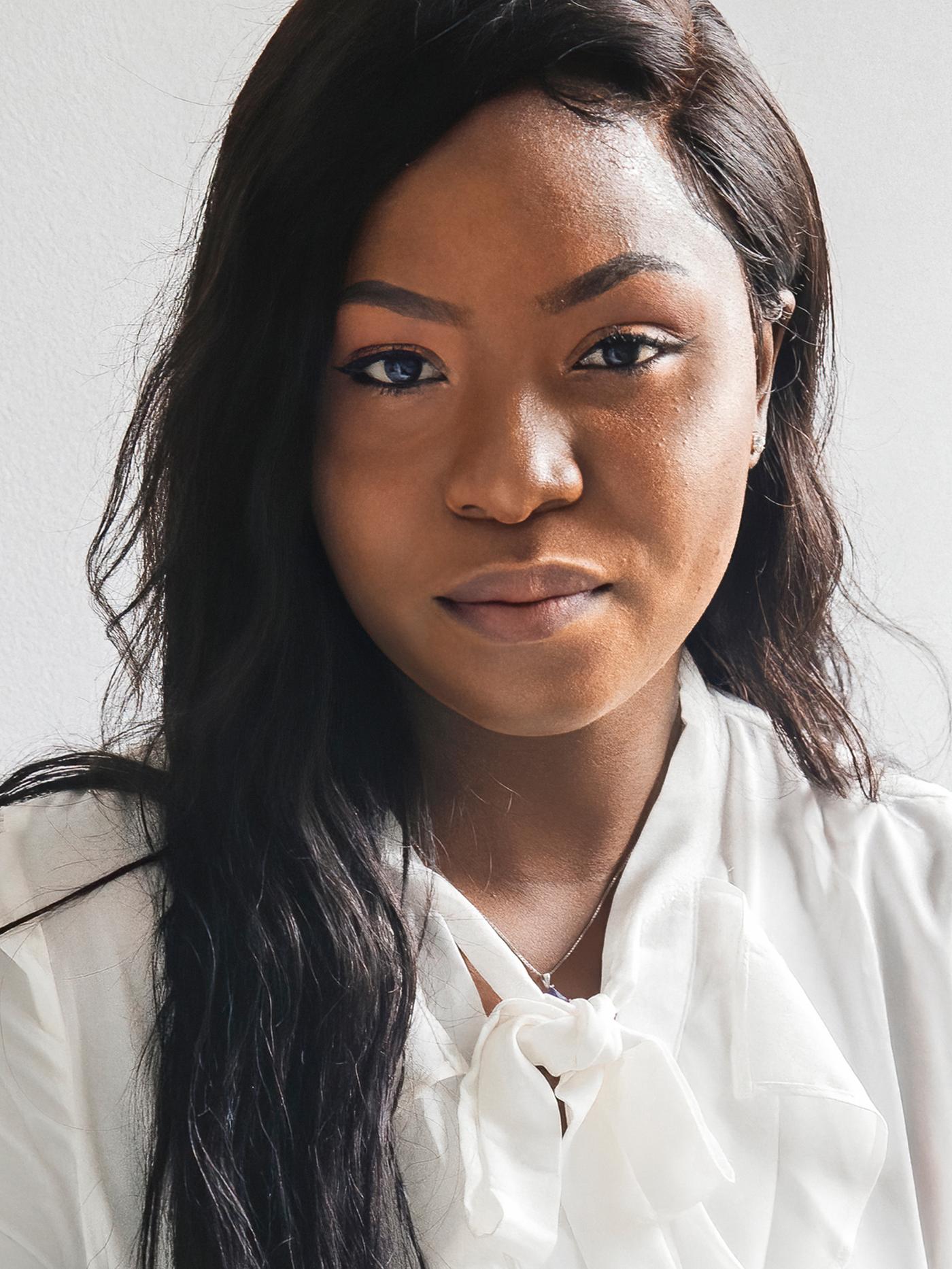 Portrait de Precious, réfugiée nigériane et collaboratrice IKEA Canada, portant un chemisier blanc.