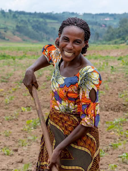Portrait of Clementine, a Congolese refugee, smiling at the camera wearing a colourful pattern.